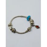 A Pandora silver bracelet with six charms; an assortment of Murano-style glass charm beads;