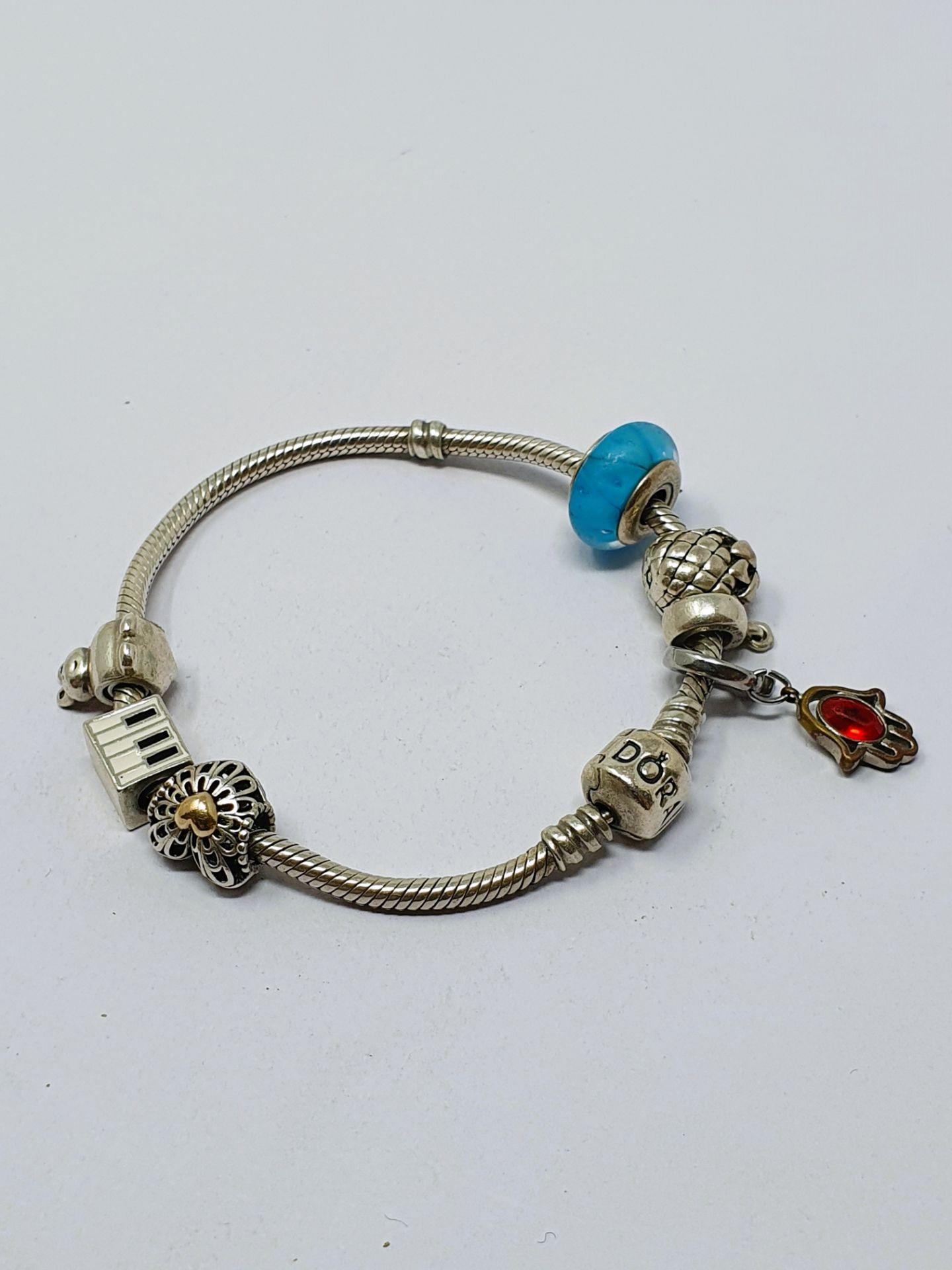 A Pandora silver bracelet with six charms; an assortment of Murano-style glass charm beads;