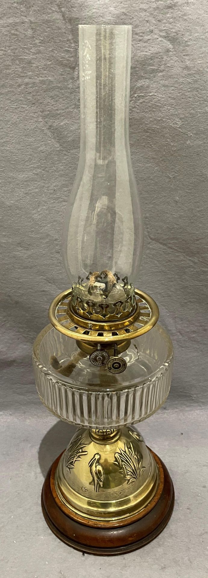A vintage brass and cut glass oil/paraffin lamp with cranes in river base and glass funnel by
