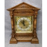 A vintage oak cased mantel clock with brass and gilt face with Roman numerals,