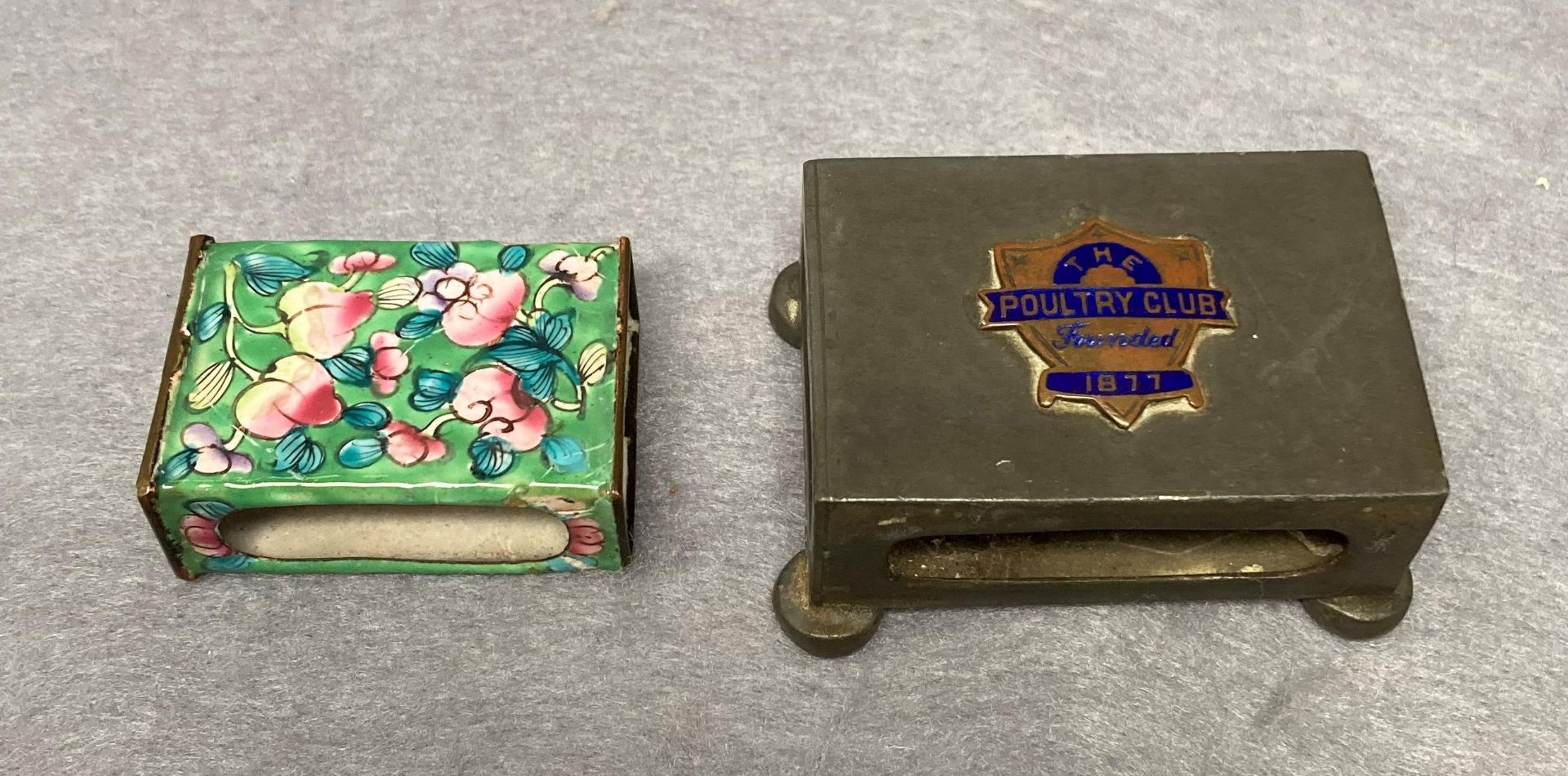 A vintage enamelled matchbox holder and a Tudric pewter matchbox holder with 'The Poultry Club,