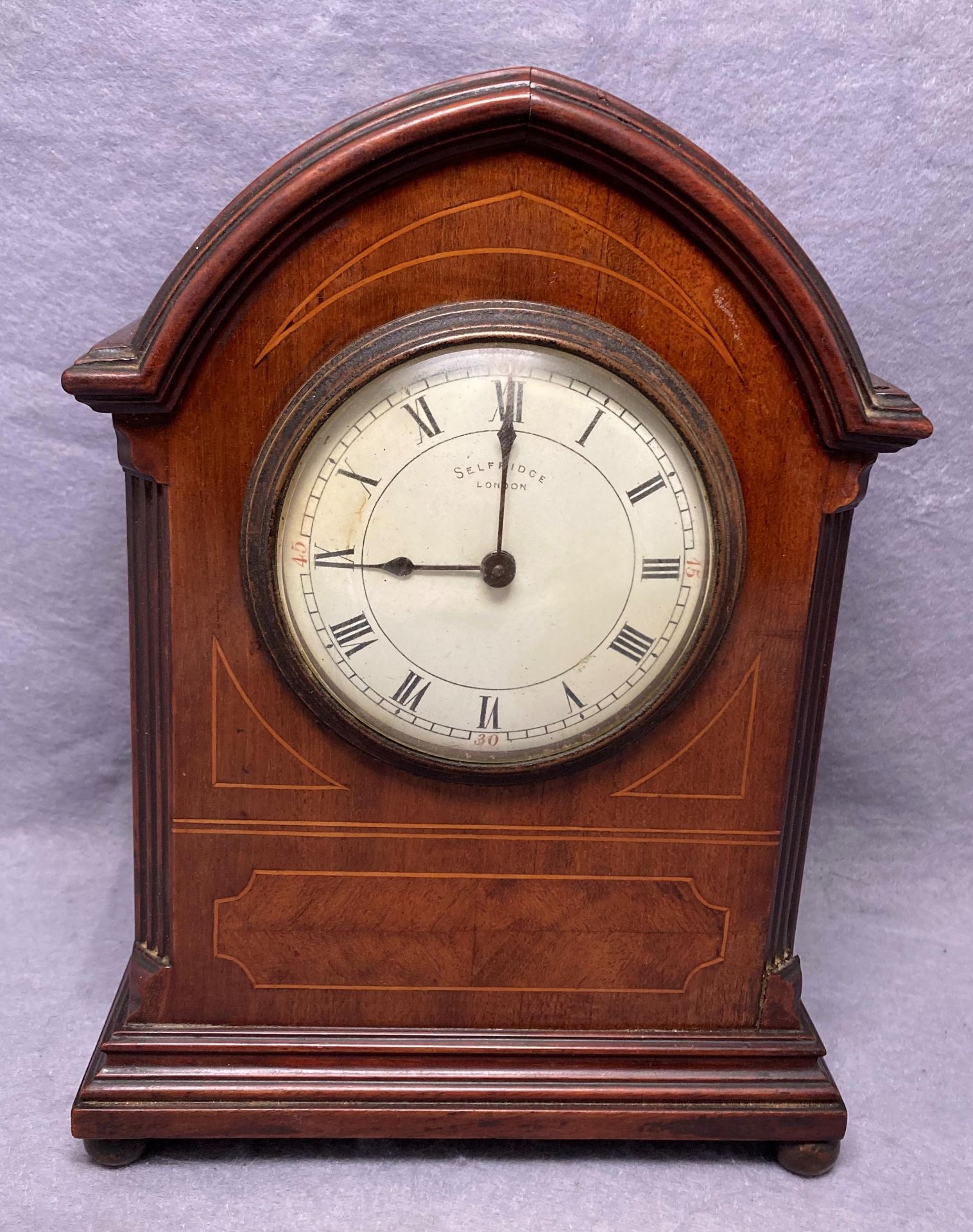 A Selfridge walnut cased mantel clock with inlay and arched top,