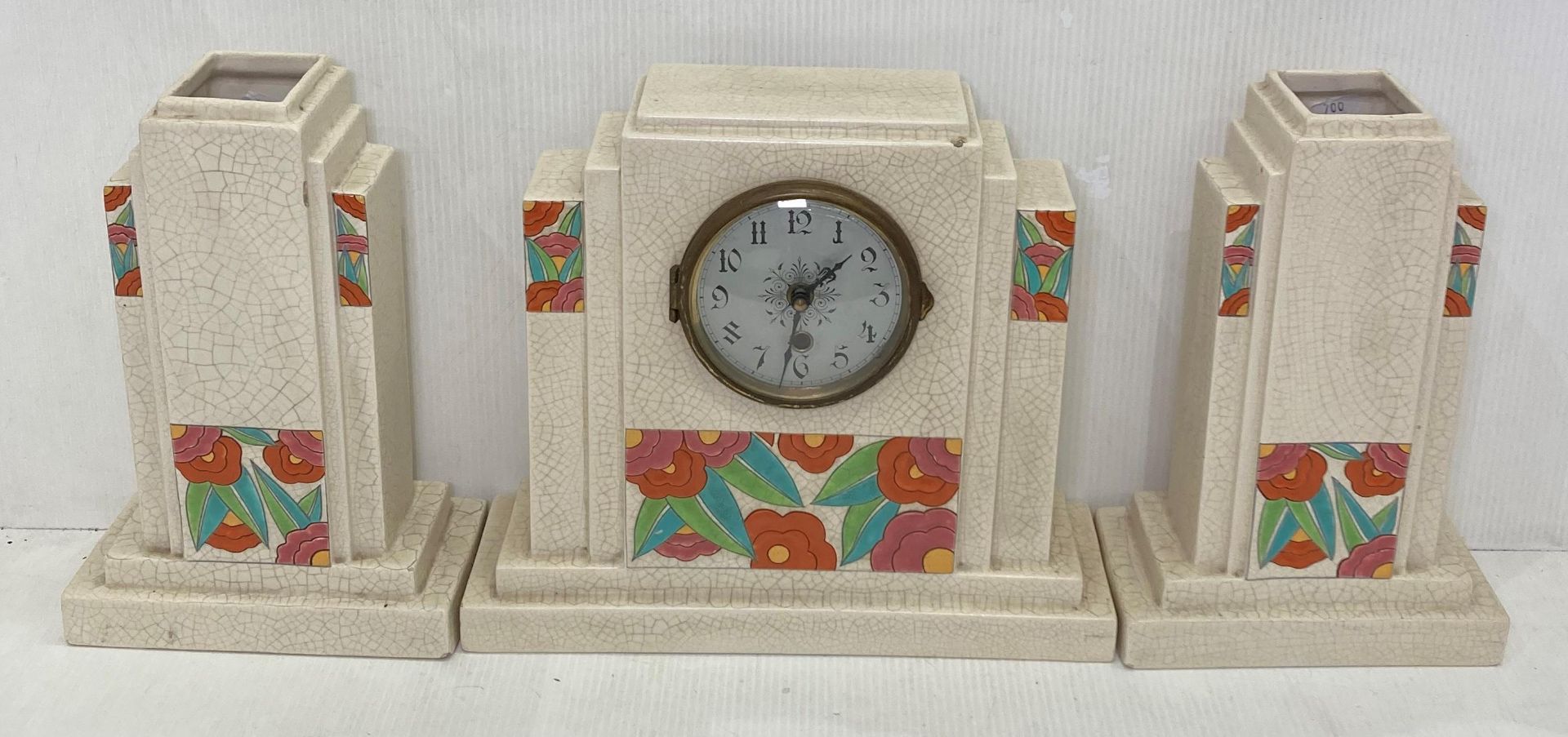 Art Deco 'Orchies' ceramic clock with floral design and crackle glaze with matching vases (saleroom