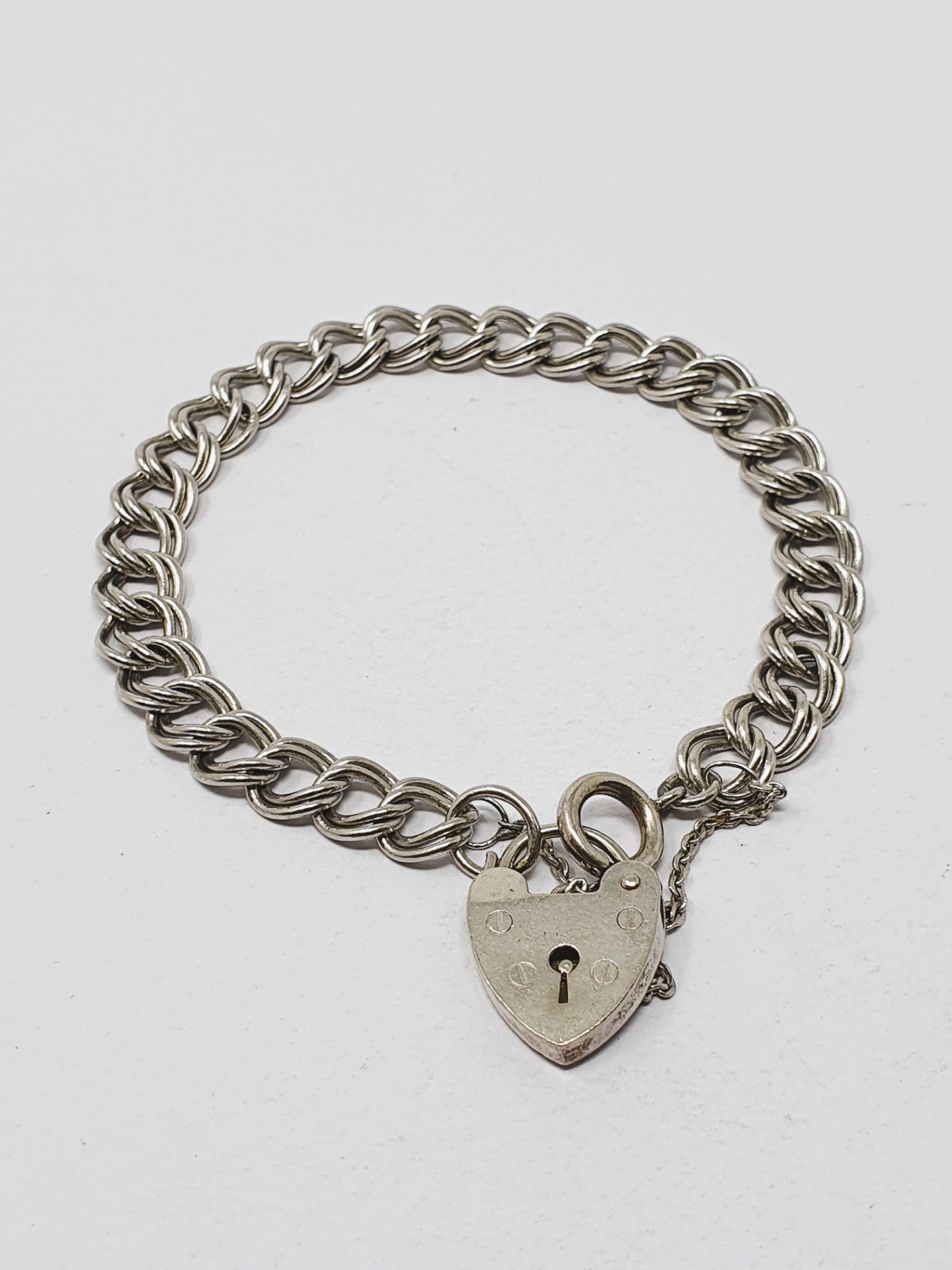 Sterling silver vintage charm bracelet, graduated curb links, padlock fastener and safety chain,