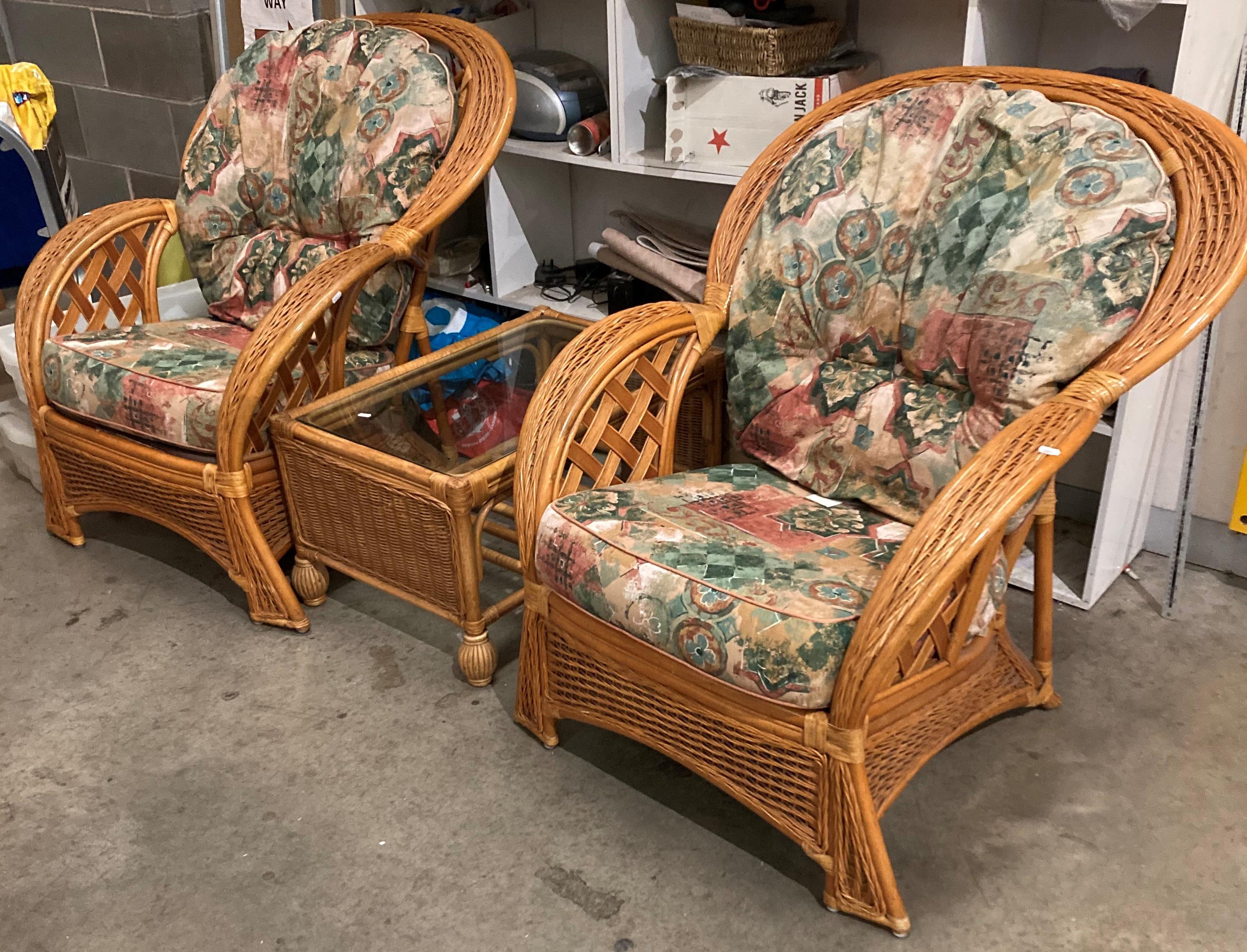 A pair of Lemoge cane loop-back conservatory armchairs and a glass-topped coffee table with