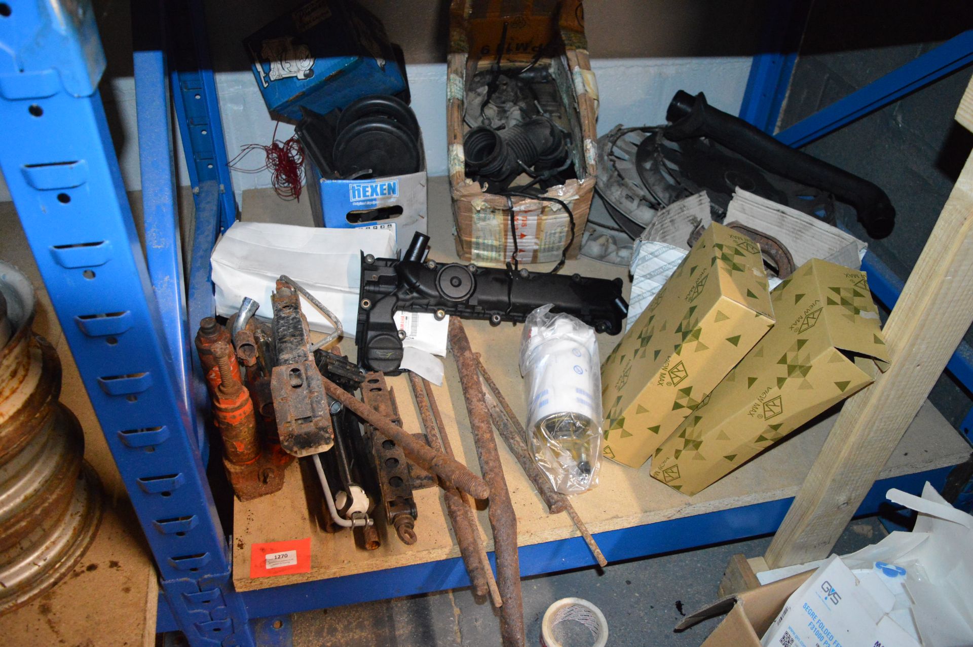 Contents of Shelf to Include Jacks, Bottle Jacks, Filter Separator, and Various Car Parts