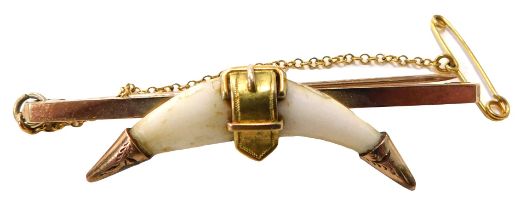 A 9ct gold fox tooth bar brooch, set with two teeth with central buckle and a rose gold cap ends on