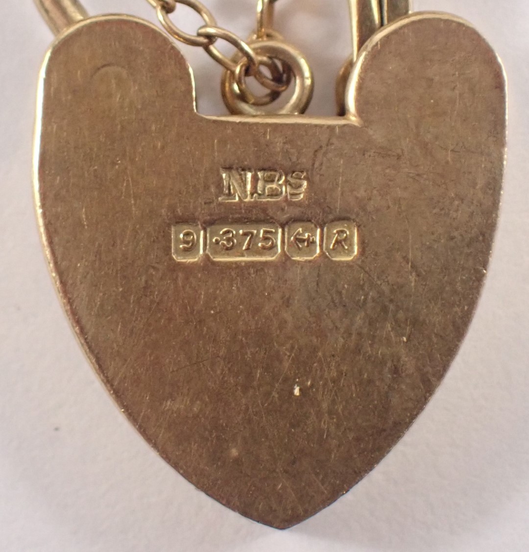 A 9ct gold charm bracelet, the curb link bracelet with heart shaped padlock and safety chain, applie - Image 2 of 3