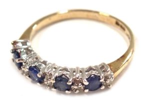 A 9ct gold half hoop dress ring, set with four pale blue round brilliant cut stones, and broken by t