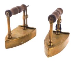Two brass flat irons, each with a turned wooden handle and hinged opening door.