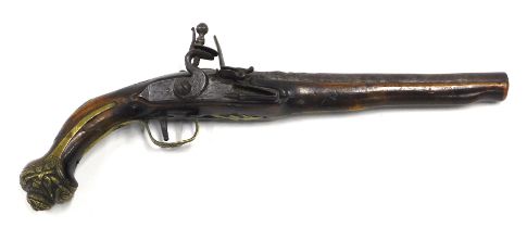 A 19thC flintlock pistol, the steel barrel embellished in brass with scroll work, indistinctly numbe