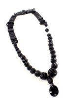 A group of jet, comprising a beaded necklace, with graduated spherical beads, the largest 2cm wide,