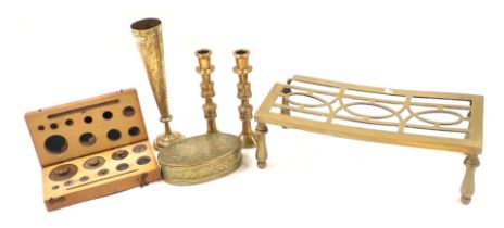 A brass rectangular trivet, pair of candlesticks, stem vase, ebonised metal oval trinket box, and bo