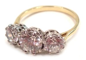 A 9ct gold three stone dress ring, set with three round brilliant cut imitation diamonds, in a raise