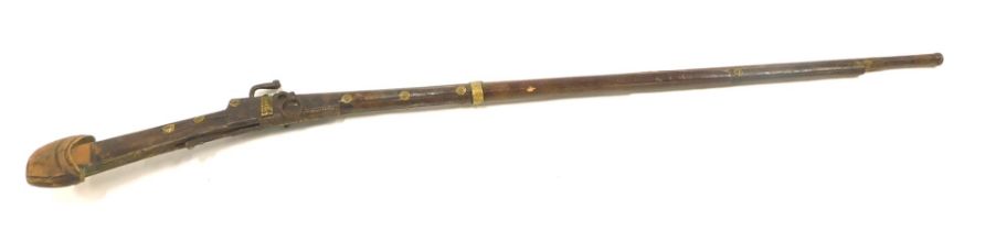 A 19thC Middle Eastern match lock musket, with brass bindings and bosses, the barrel measures 112cm