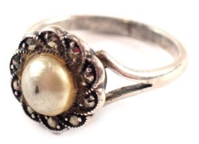 A silver dress ring, formed as a marcasite floral cluster, with central cultured pearl with V splaye