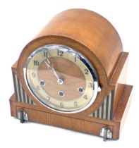 An Art Deco oak cased mantel clock, the arched top above a chrome and silvered dial, with striped an