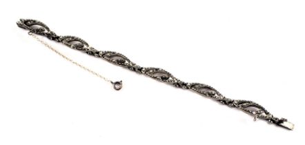 A marcasite bracelet, each link of oval shaped form set with marcasite, with clip and safety chain,