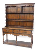 A Titchmarsh & Goodwin oak dresser in 18thC style, the raised back with panelled door, and two shelv