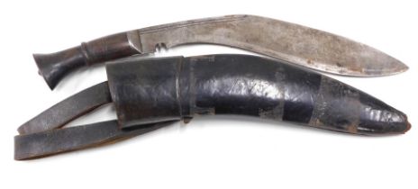 A kukri knife, with carved wooden grip and leather scabbard, the blade measures 31cm.