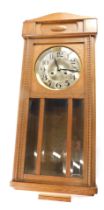 A 1920s oak cased wall clock, the silvered dial with Arabic numerals, 79cm high.