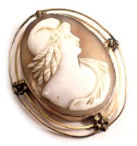 A shell cameo brooch, the oval cameo depicting maiden with helmet, in a two row outer wire border wi