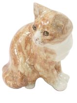 A Winstanley seated tabby cat, ginger design with yellow glass eyes, signed to underside, 21cm high.