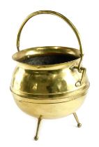 A late 19thC brass coal bucket, in arts and crafts style, of cauldron form with tapering legs and lo