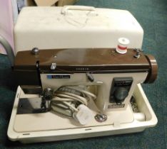 A cased New Home sewing machine and pedal.