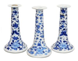 A pair of Qing dynasty Chinese blue and white porcelain candlesticks, of outswept form, decorated wi