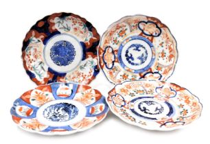 Four Japanese Imari dishes, of fluted form, reserve decorated with panels of flowers or birds, Meiji