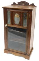 A Victorian stained pine bedside cabinet, with a carved pediment and single door enclosing mirrored