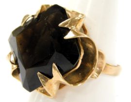 A 9ct gold and smoky quartz ring, the square cut stone in a scrolling claw setting, approximately 7.