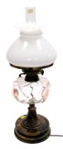 A Victorian oil lamp, with a frosted shade, clear and pink blown glass central reservoir, on a brass