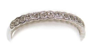 An 18ct gold white gold and diamond half hoop eternity ring, set with seventeen round brilliant cut