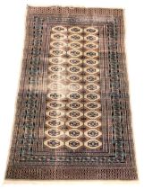A Middle Eastern bordered rug, with geometric central panel and traditional stylised motifs in blue