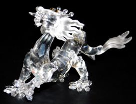 A Swarovski Crystal model of an imperial dragon, raised on a wooden stand, 16cm wide.