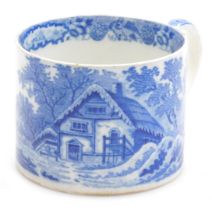 An early 19thC small pottery tankard, printed in blue and white with a thatched cottage pattern, c18