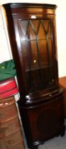 A mahogany corner cabinet, glazed door to top, panelled door below, raised on bracket feet.