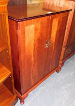 A mahogany veneered and inlaid two door cupboard, raised on short cabriole supports.