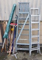 Garden tools, including rakes, forks, etc. bamboo canes and two ladders.