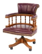 A 20thC burgundy leather oak framed captain's chair, with overstuffed leather back and seat, with br