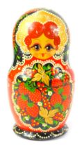 A Russian Matryoshka nesting doll, decorated with fruit against a red and black ground, 19.5cm high.
