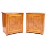 A pair of pine bedside cabinets, each rectangular top above a panelled door enclosing single shelf,