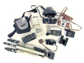 A group of camera equipment and optics, to include a Nikon camera, Nikon Nikkor 135mm f-2.8 lens, tr