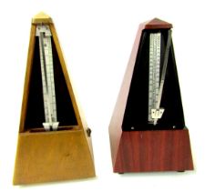 A Maezel Paquet oak cased metronome, 24cm high, bearing label for Paquet Made in France, and another