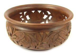 An Eastern hardwood carved fruit bowl, of circular form, the body with pierced and carved decoration