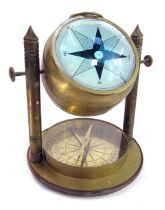 A reproduction brass domed ships compass, the spherical magnifying domed top, in a brass mounted out
