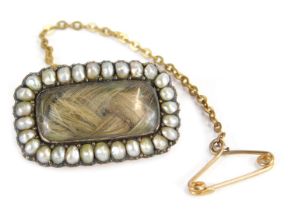 A Victorian memorial brooch, with rectangular window panel, inset plated lockets of hair, with seed