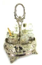 A late Victorian silver plated cruet, with central ring handle and six sections for bottles, the bas